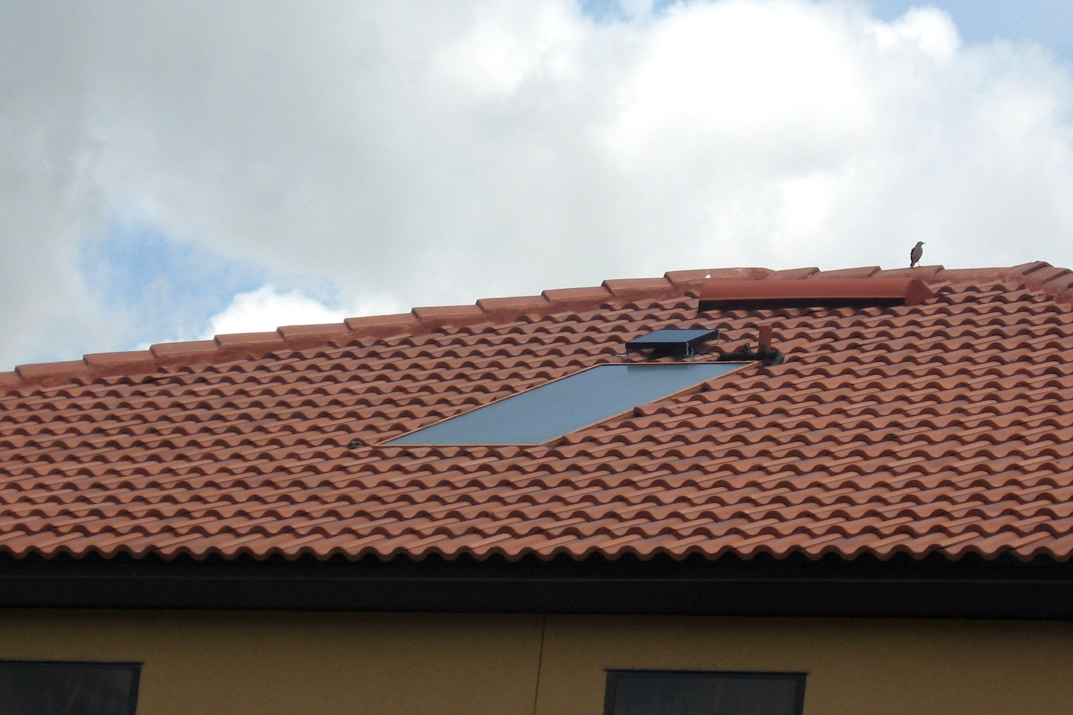 Solar water heating panels can be installed on different roofing materials, such as this red barrel tile, and can have pumps powered by a small photovoltaic panel.